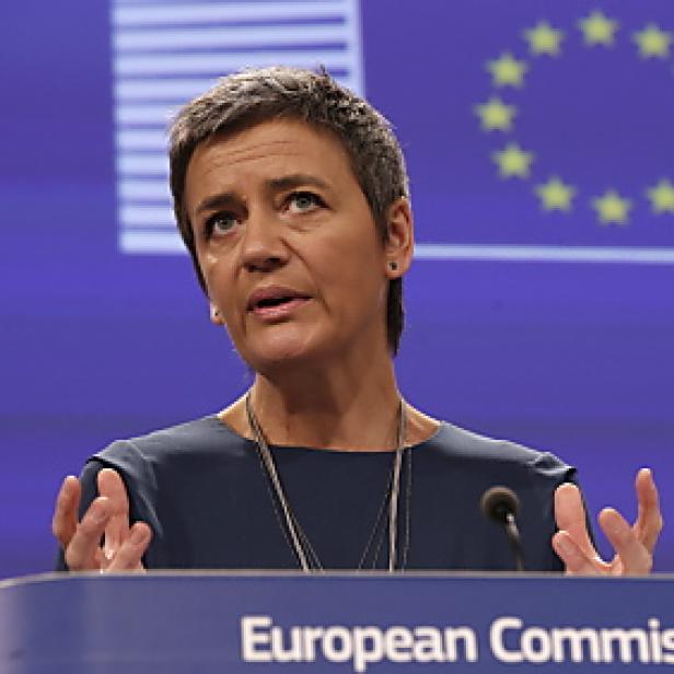 Margrethe Vestager spricht vor dem Hintergrund der Europaflagge.