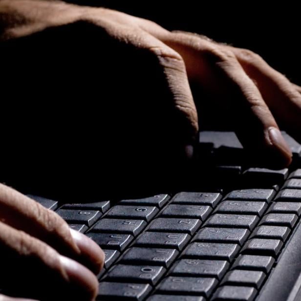 male hands on the keyboard,low key and high contrast,may suggest cyber cryme, hacking,spying