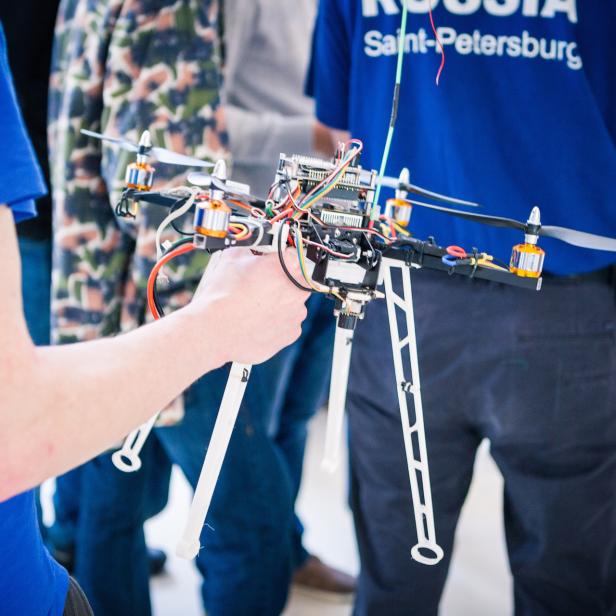 Eine Person hält eine selbstgebaute Drohne in der Hand.
