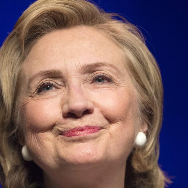 Ein Porträt von Hillary Clinton vor einem blauen Hintergrund.