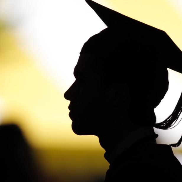 A view shows the silhouette of a student with a graduation cap as students take their seats for the diploma ceremony at the John F. Kennedy School of Government during the 361st Commencement Exercises at Harvard University in Cambridge, Massachusetts, in this May 24, 2012 file picture. With their remuneration levels and reputation under attack in the wake of the global financial crisis, investment banks are having to work harder to attract graduates. Gone are the big, brash corporate presentations, instead it&#039;s all about corporate responsibility, diversity and a long-lasting career. To match story BANKS/GRADUATES REUTERS/Brian Snyder/Files (UNITED STATES - Tags: EDUCATION)