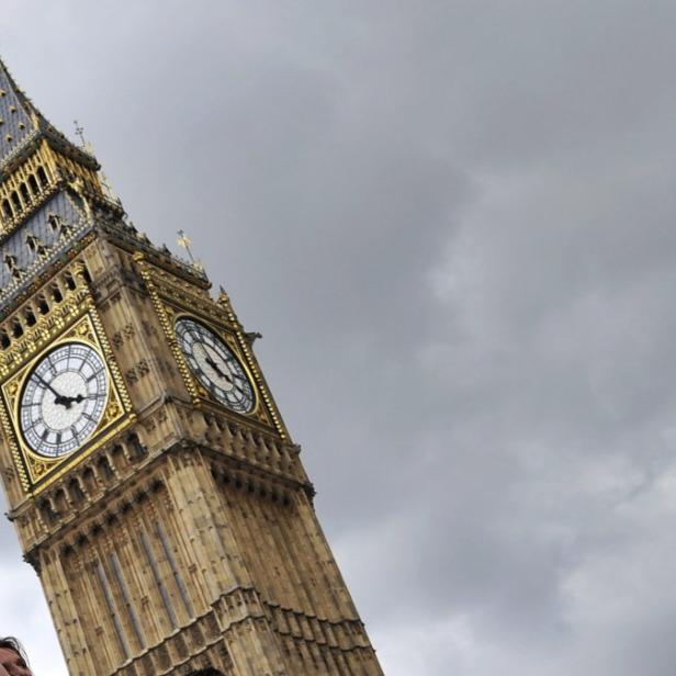 Ein Mädchen vor dem Big Ben in London unter einem bewölkten Himmel.