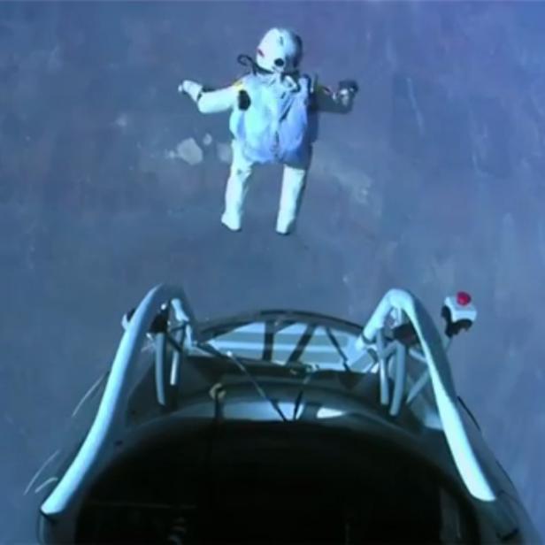 Ein Fallschirmspringer springt aus großer Höhe über die Erde.