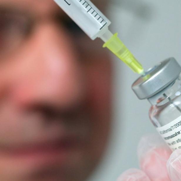 Eine medizinische Fachkraft zieht eine Impfdosis aus einer Durchstechflasche auf.