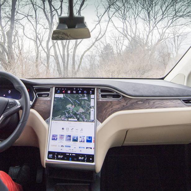 Innenansicht eines Tesla Model X mit Navigationssystem auf dem Bildschirm.