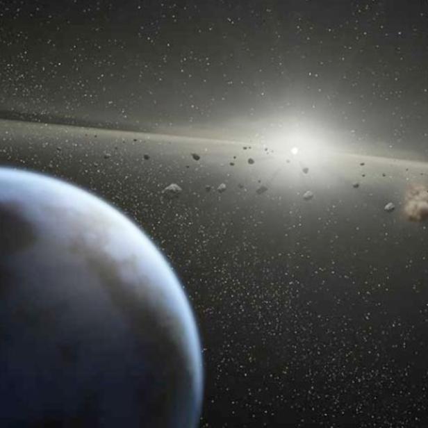Ein blauer Planet ist von einem Asteroidengürtel umgeben, im Hintergrund ein heller Stern.