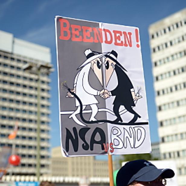 Ein Protestschild fordert die Beendigung von NSA und BND mit einer Karikatur von Spy vs. Spy.
