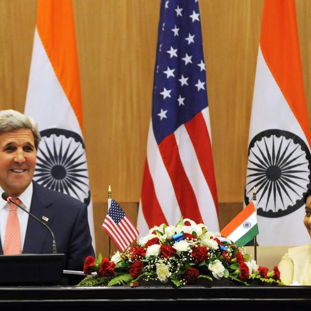 John Kerry und Sushma Swaraj bei einem Treffen vor US-amerikanischen und indischen Flaggen.