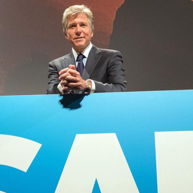 Ein Mann im Anzug steht hinter einem Podium mit dem SAP-Logo.