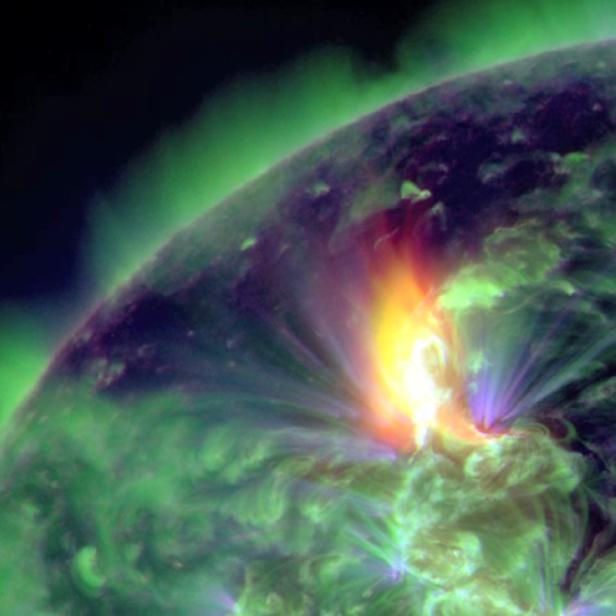 Ein Ausbruch auf der Sonne, sichtbar als helle, gelb-orangefarbene Eruption.