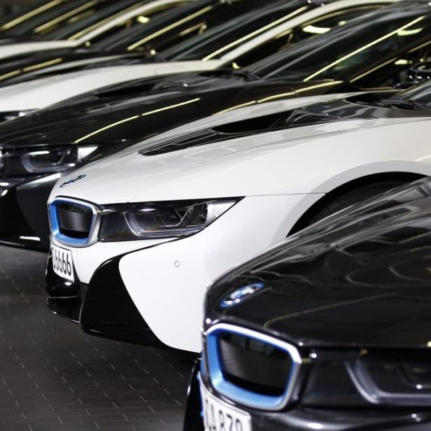 Eine Reihe von schwarzen und weißen BMW i8-Fahrzeugen steht nebeneinander.