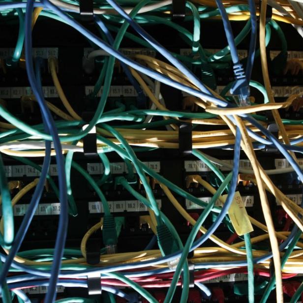 Ein Serverschrank mit einem Gewirr von farbigen Netzwerkkabeln.