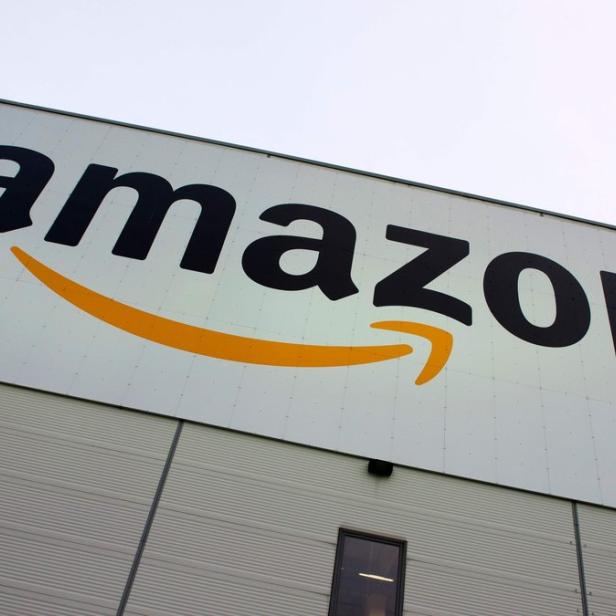 Das Amazon-Logo an der Fassade eines Lagerhauses.