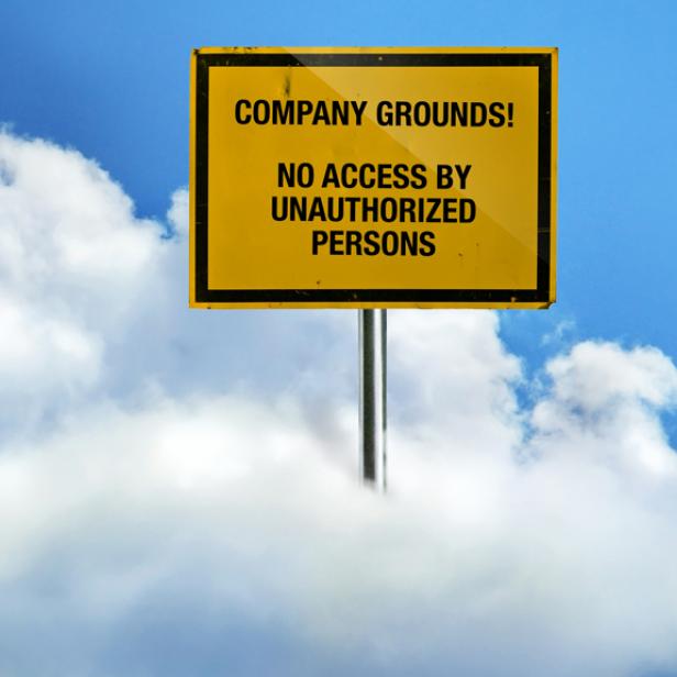 Ein gelbes Schild mit der Aufschrift „Company Grounds! Kein Zutritt für Unbefugte“ vor blauem Himmel und Wolken.