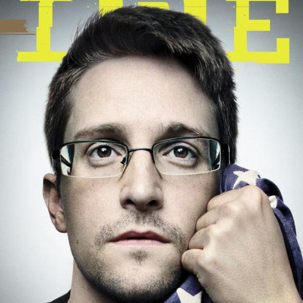 Edward Snowden hält eine amerikanische Flagge an sein Gesicht.