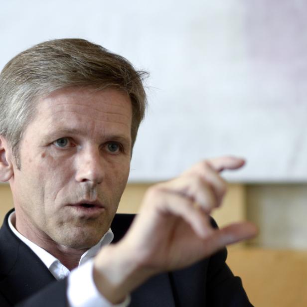 Ein Mann im Anzug gestikuliert mit der Hand.