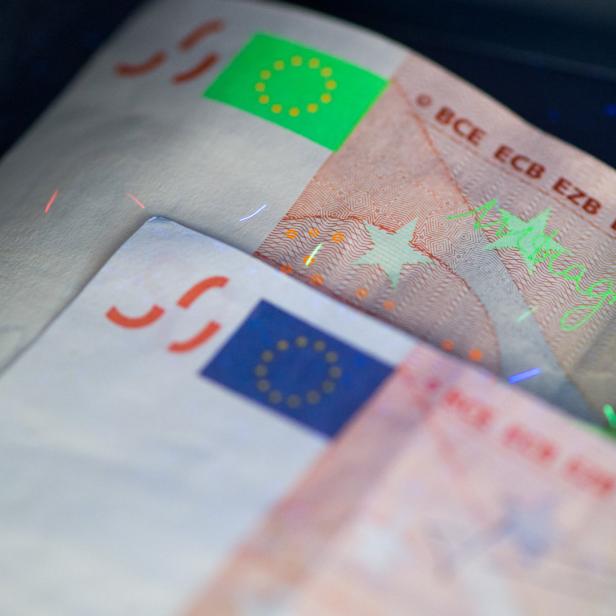Zwei 50-Euro-Scheine unter UV-Licht zeigen Sicherheitsmerkmale.