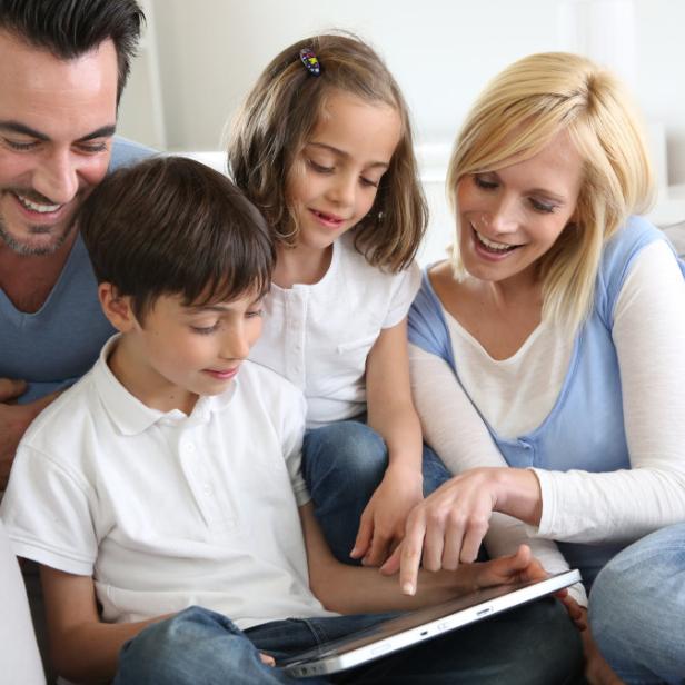 Family relaxing with kids and using digital tablet