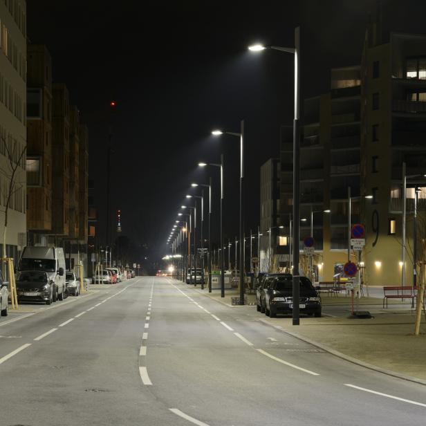Eine nächtliche Aufnahme der Maria-Tusch-Straße in Wien mit beleuchteten Straßenlaternen.