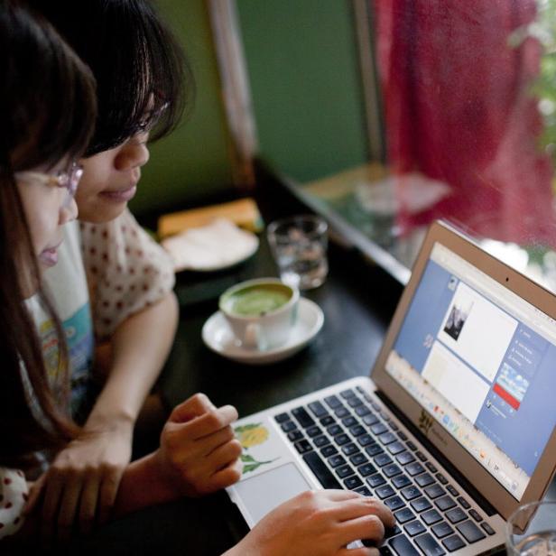 epa03847752 Two women use social networking site Tumblr in a cafe in Hanoi, Vietnam, 02 September 2013. A new Vietnamese government decree banning internet users from posting information found online on social media sites took affect on 01 September. According the decree, blogs and social media sites, such as Twitter and Facebook, should be used to provide and share personal information only. EPA/LUONG THAI LINH