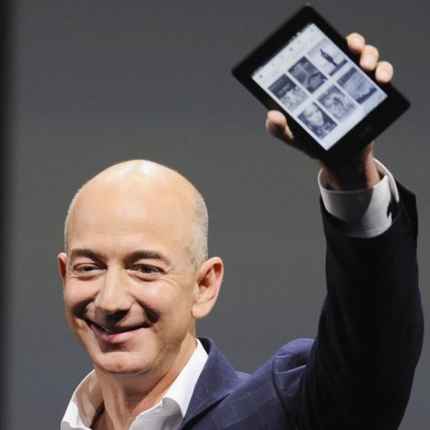 Amazon CEO Jeff Bezos holds up a Kindle Paperwhite during Amazon&#039;s Kindle Fire event in Santa Monica, California September 6, 2012. REUTERS/Gus Ruelas (UNITED STATES - Tags: SCIENCE TECHNOLOGY BUSINESS)