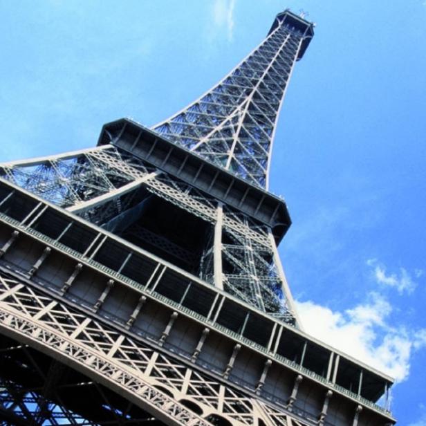 Der Eiffelturm in Paris, aufgenommen aus einer niedrigen Perspektive gegen einen blauen Himmel.