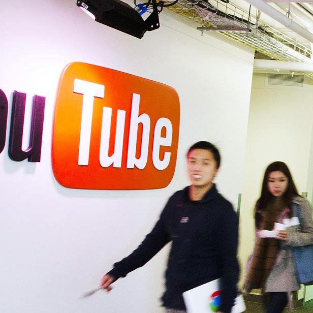 People walk by a YouTube sign at the new Google office in Toronto, in this November 13, 2012 file photo. A U.S. judge on May 15, 2013 denied class-action status to copyright owners suing Google Inc over the use of material posted on YouTube without their permission