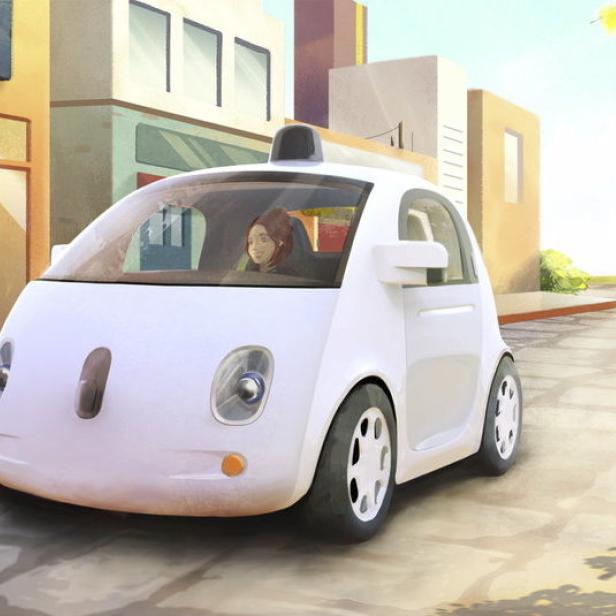 Ein autonomes, weißes Google-Auto fährt eine Straße entlang.
