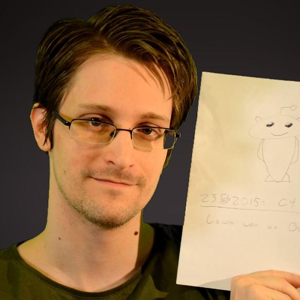 Edward Snowden hält ein Blatt Papier mit einer Zeichnung des Reddit-Logos.