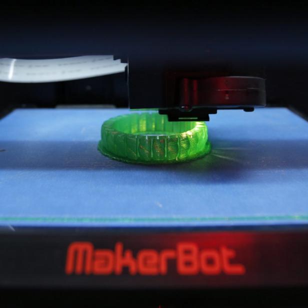 Ein grüner Gegenstand wird in einem MakerBot 3D-Drucker hergestellt.