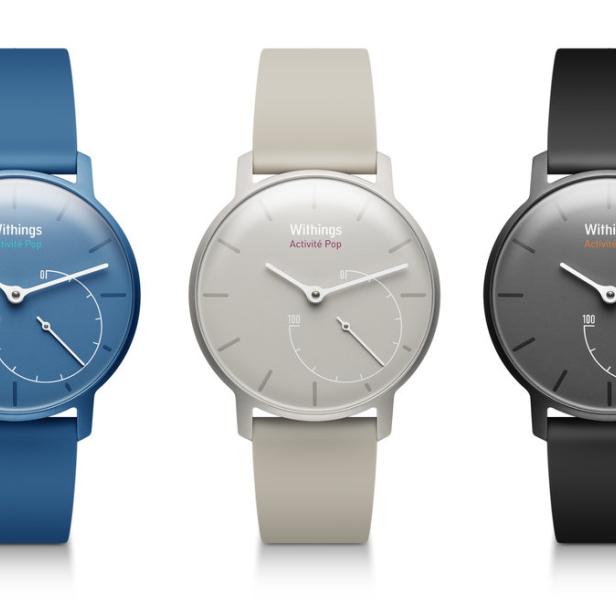 Drei Withings Activité Pop Uhren in Blau, Beige und Schwarz vor einem weißen Hintergrund.