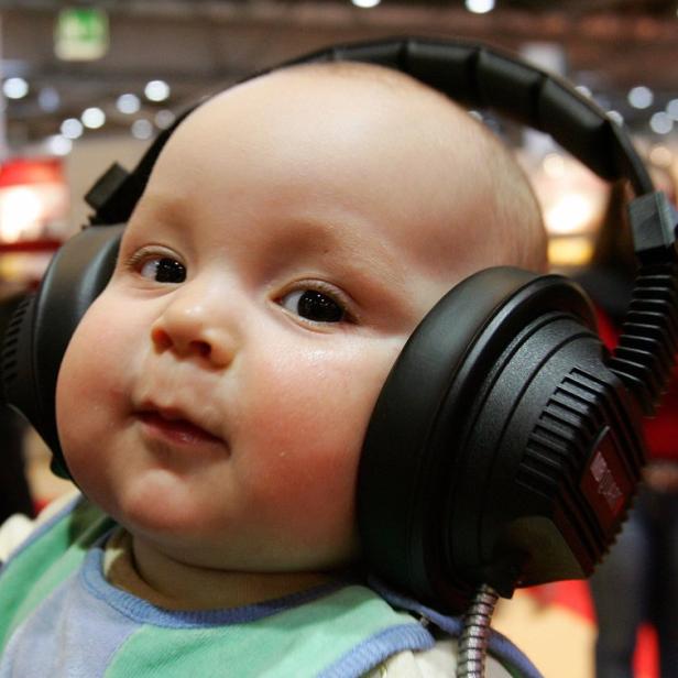 Ein Baby trägt große, schwarze Kopfhörer.