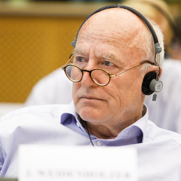 Ein Mann mit Brille und Kopfhörern schaut aufmerksam zur Seite.