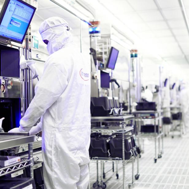 Ein Mitarbeiter von Infineon arbeitet in einem Reinraum an Produktionsanlagen.