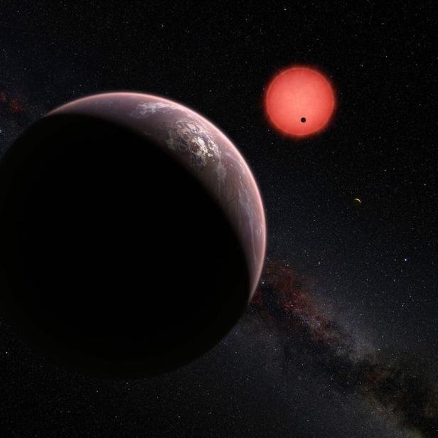 Eine rote Sonne und ein Planet sind vor einem Sternenhintergrund zu sehen.