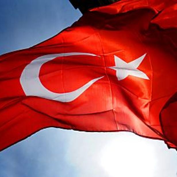 Die türkische Flagge weht im Wind vor einem blauen Himmel.