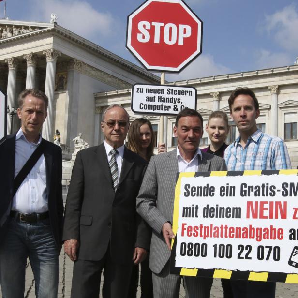 Eine Gruppe von Menschen demonstriert vor dem österreichischen Parlament gegen neue Steuern auf Handys und Computer.