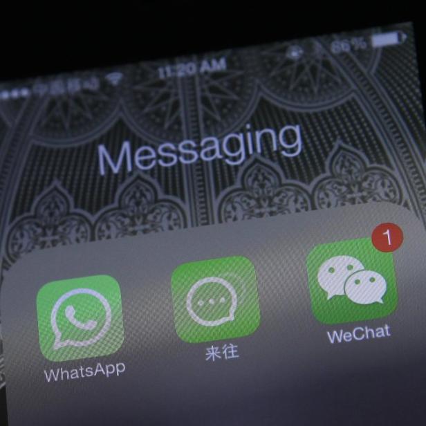 Auf dem Bildschirm eines Smartphones sind die Apps WhatsApp, WeChat und Laiwang zu sehen.