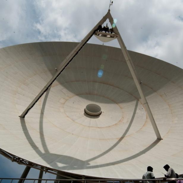 epa03721225 ISRO employees stand in front of the 32 meter big dish antenna at Deep Space Network (DSN) station, Telemetry Tracking and Command Network Centre (ISTRAC) near Byalalu village on the outskirts of Bangalore, India, on 28 May 2013. The new Indian indigenous Regional Navigational Satellite System or the IRNSS of single channel SPS and RS dual frequency receiver is being carried out in house to facilitate the testing of Navigation payload, will provide services like Standard Positioning Service on land, air and water. Three satellites will be placed in the geostationary equatorial orbit (GEO) at 34, 83 and 131.5 degree east and two satellites each in the geosynchronous orbit (GSO) with equator crossing at 55 and 111.5 degree east at an inclination of 29 degree.î, the ground segment of IRNSS constellation would consist of a Master Control Center (MCC), ground stations to track and estimate the satellitesí orbits and ensure the integrity of the network (IRIM), and additional ground stations to monitor the health of the satellites with the capability of issuing radio commands to the satellites (TT&amp;C stations). EPA/JAGADEESH NV