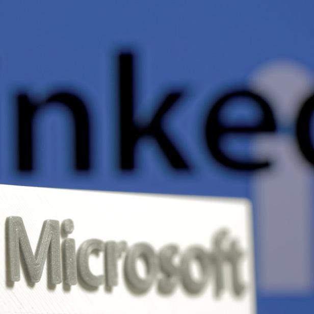 Das Microsoft-Logo steht vor einem verschwommenen LinkedIn-Logo.