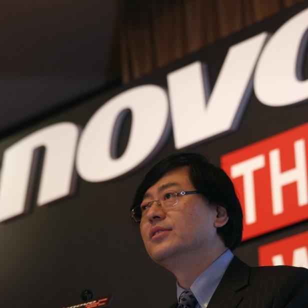 Ein Mann spricht vor einem Lenovo-Logo.
