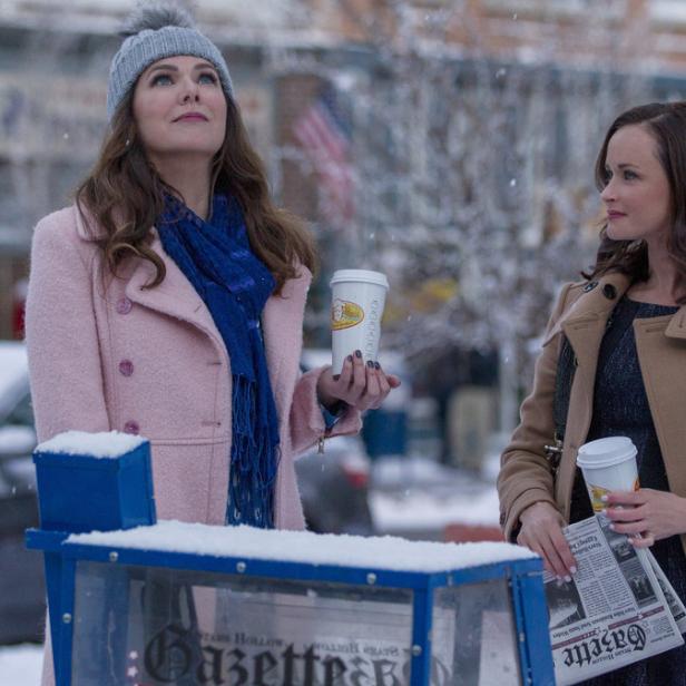 Zwei Frauen stehen im Schnee mit Kaffee und Zeitungen in Stars Hollow.