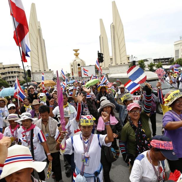 Eine Menschenmenge demonstriert mit thailändischen Flaggen vor dem Demokratie-Denkmal in Bangkok.
