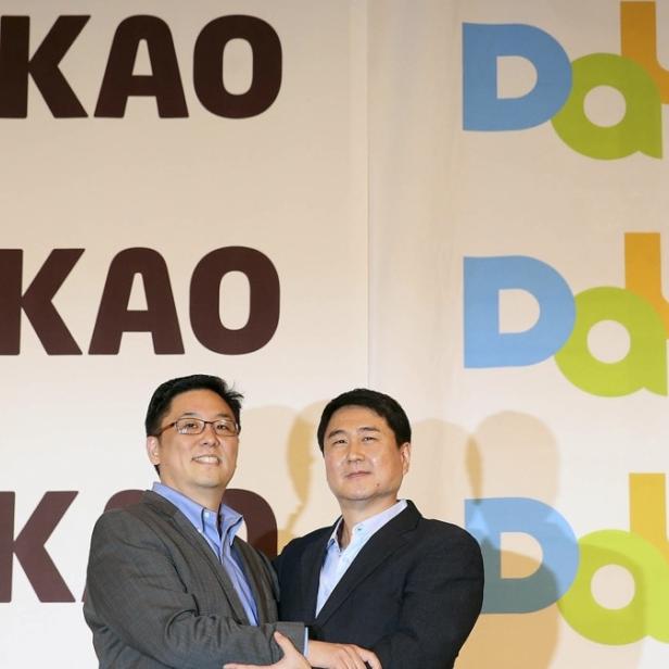 Daum CEO Choi Sae-hoon (li.) schüttelt die Hand von Kakao CEO Sirgoo Lee (re.)