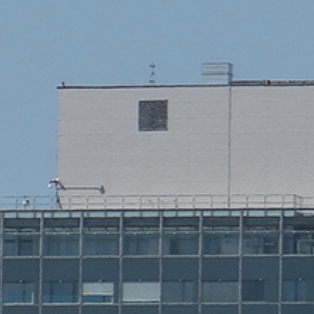 Ein mehrstöckiges Gebäude mit einer Antenne auf dem Dach.