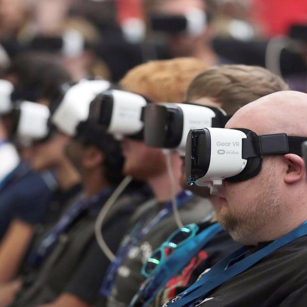 Eine Gruppe von Menschen sitzt nebeneinander und trägt VR-Headsets.