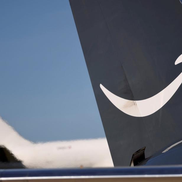 Das Heck eines Flugzeugs mit dem Amazon-Logo vor blauem Himmel.