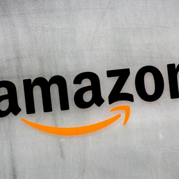Das Amazon-Logo auf einer grauen Wand.
