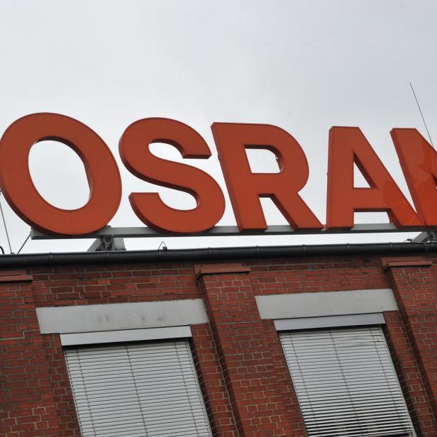 Das Osram-Logo auf einem Backsteingebäude unter einem grauen Himmel.