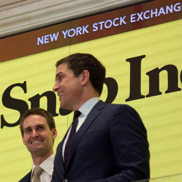 Männer in Anzügen vor einer Anzeigetafel der New York Stock Exchange mit dem Schriftzug „Snap Inc.“.